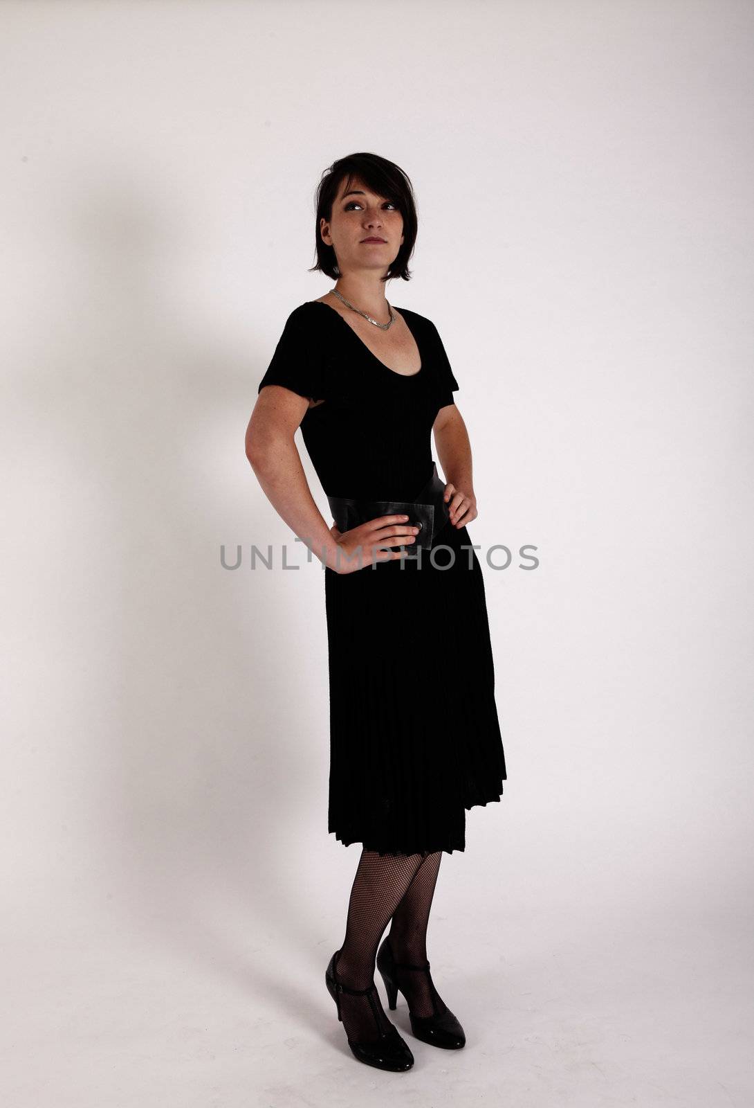 a young woman in strict black dress in studio looking like widow or nanny