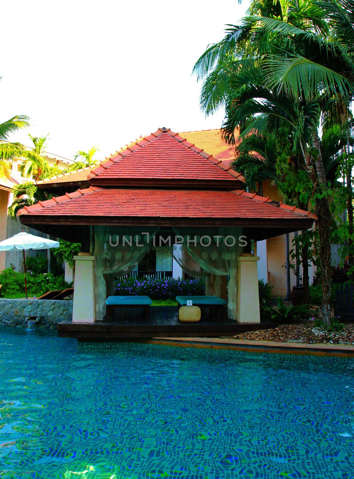 Outdoor massage in tropical garden with swimming pool