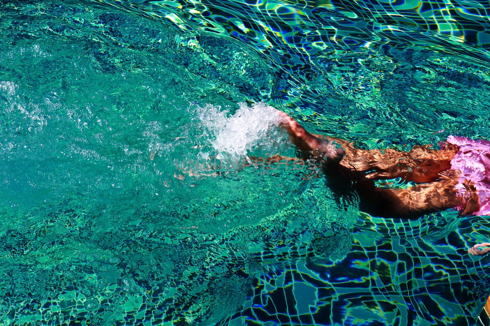 kid legs with swimsuit swimming on a blue water pool  by nuchylee