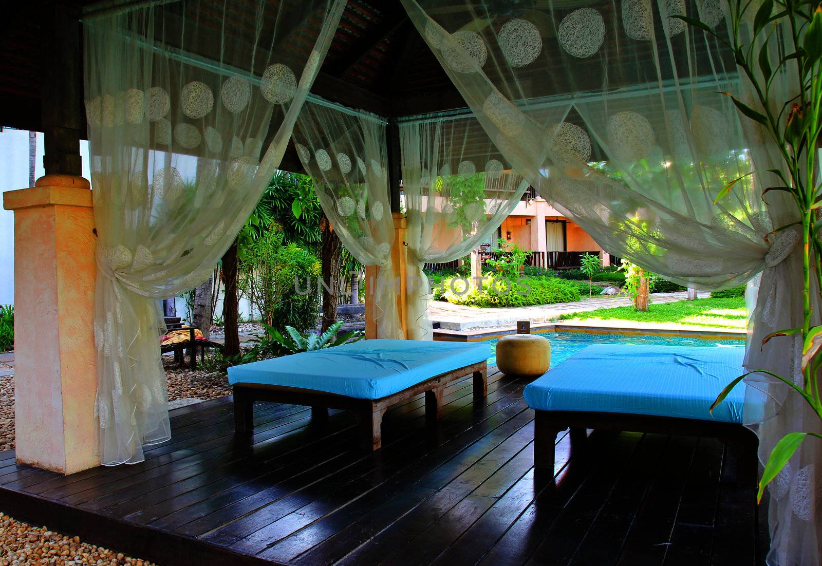 Outdoor massage in tropical garden with swimming pool