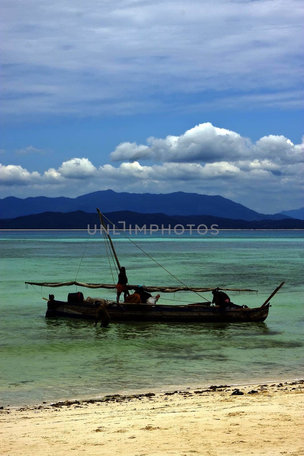 people  boat palm  rock stone branch hill lagoon and coastline in madagascar nosy be