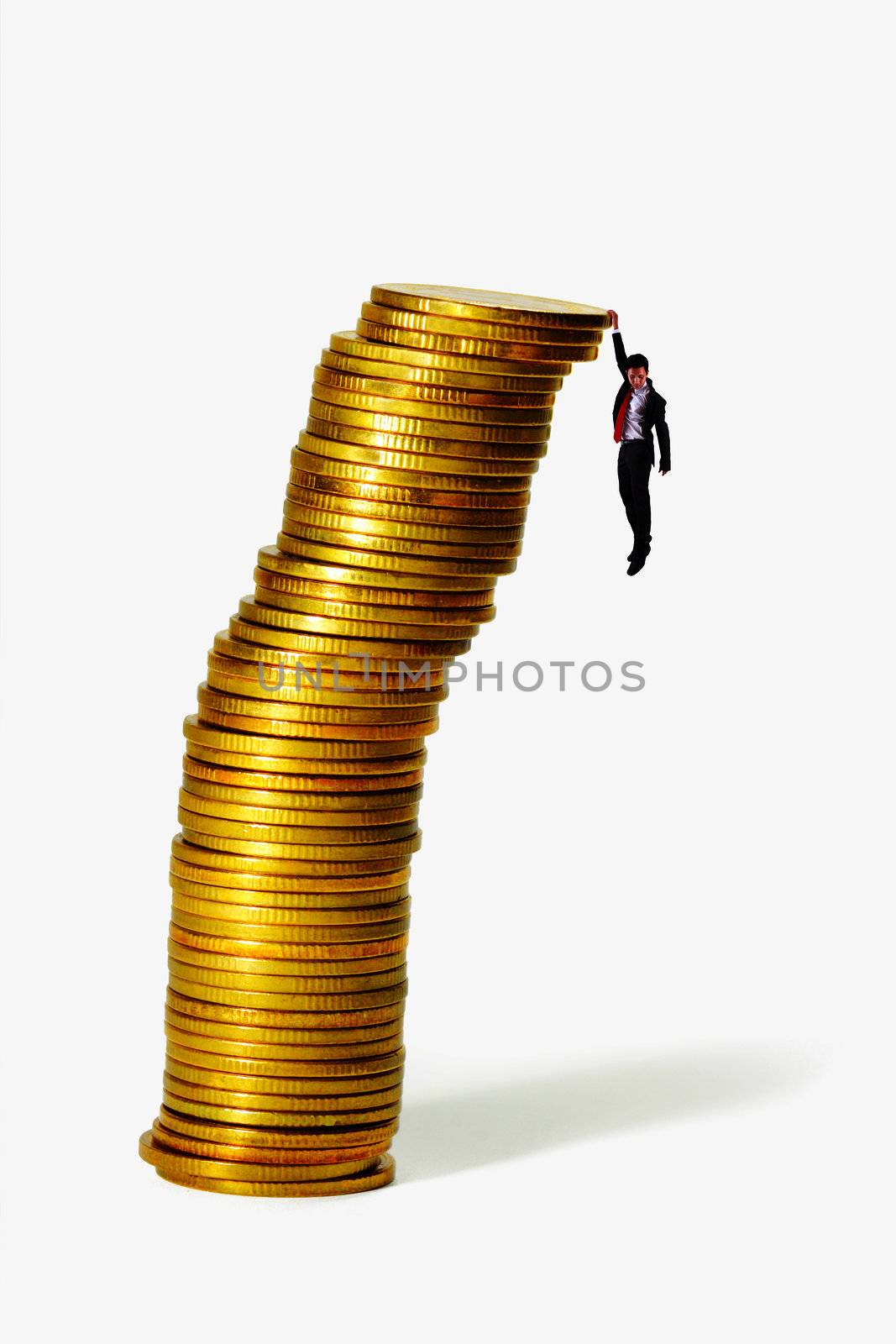Businessman hang on Gold coin heap and looking down on ground
