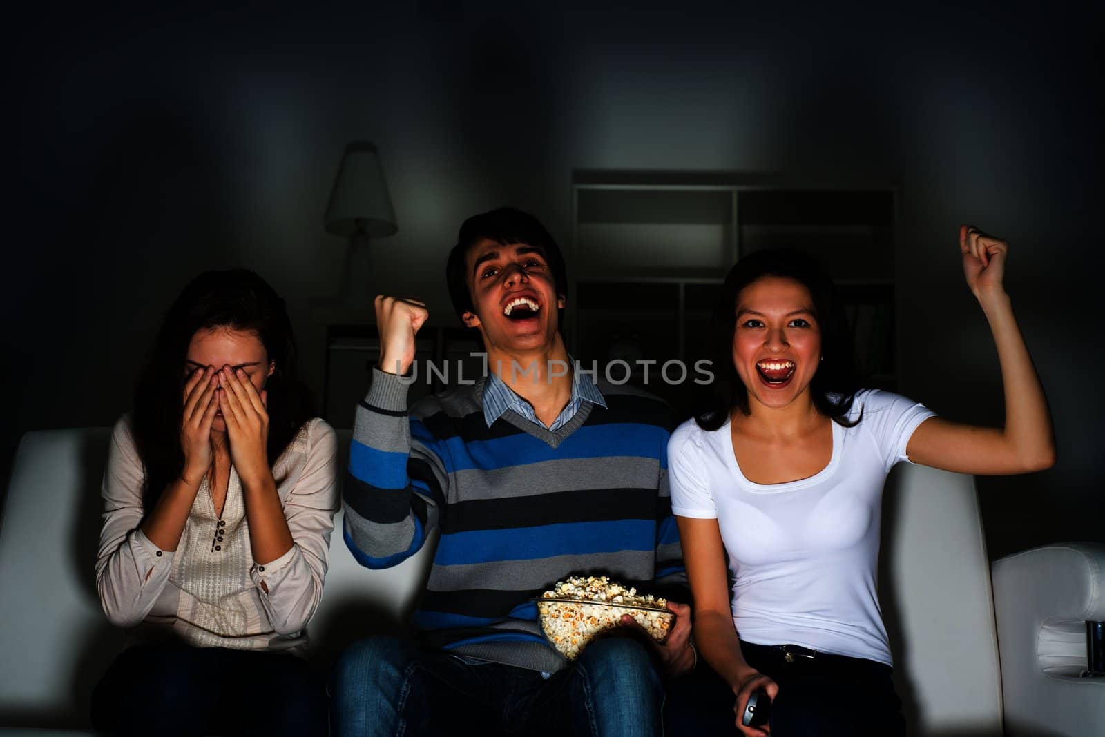 group of young people watching TV on the couch, sports fans