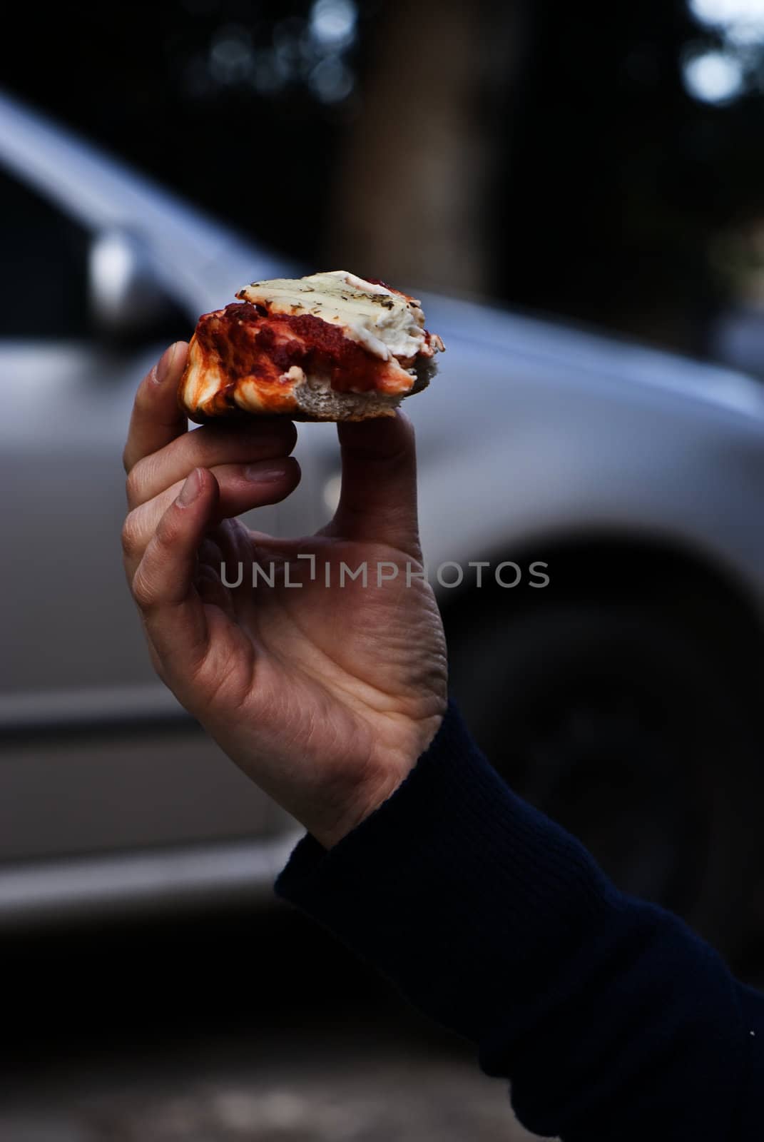 Tasty Italian pizza and hand  on the road