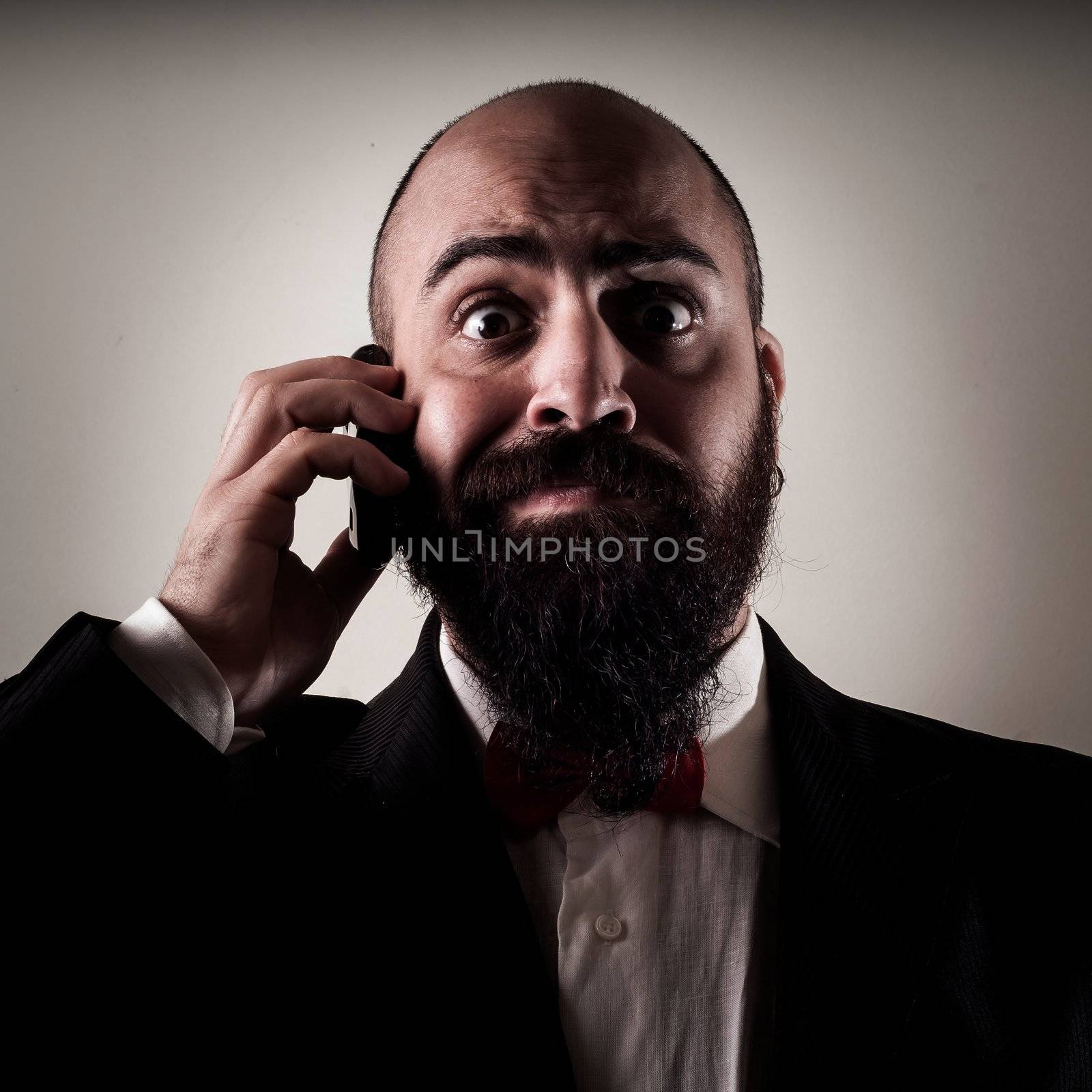  funny elegant bearded man on the phone on vignetting background