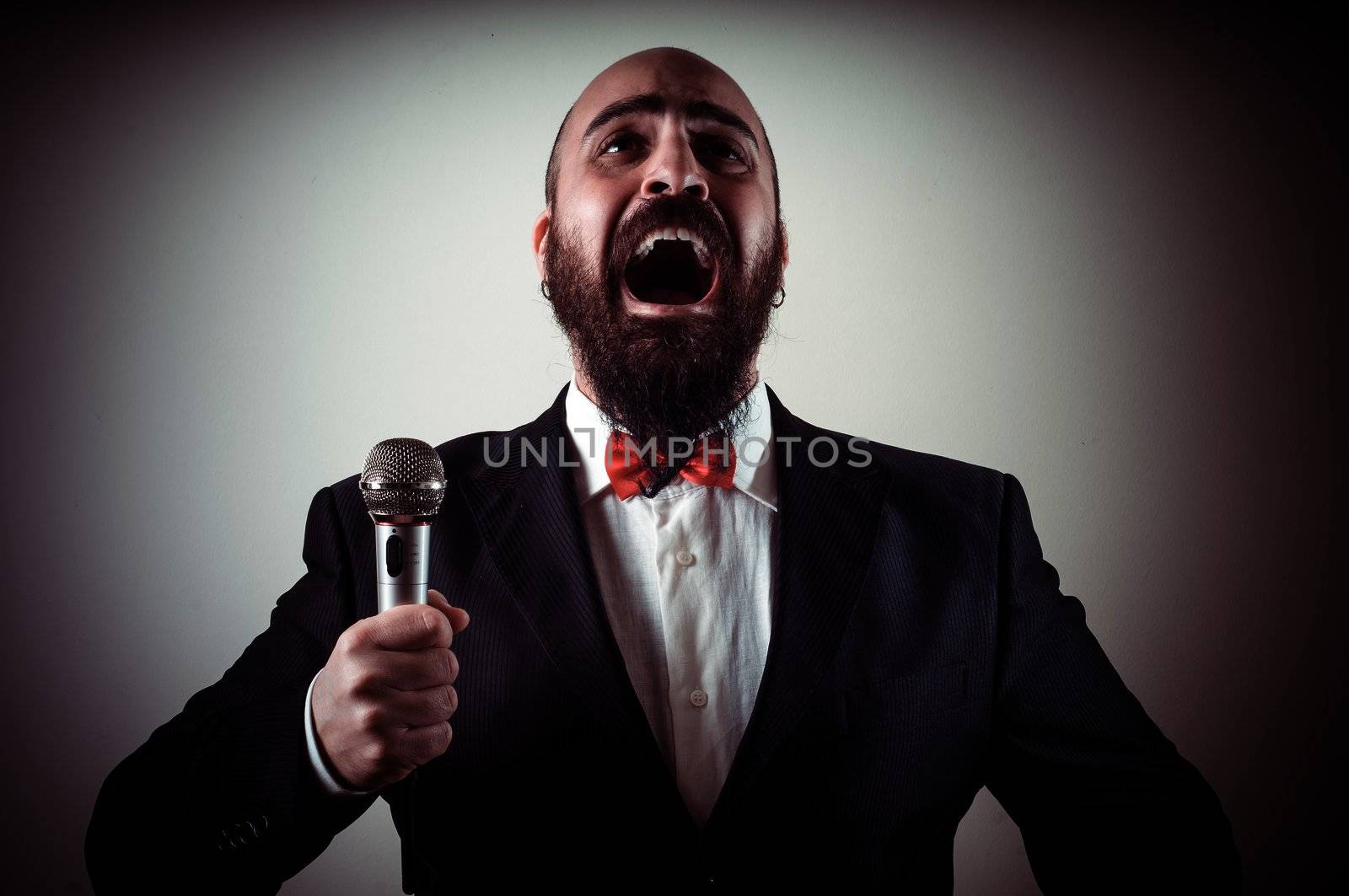  funny elegant singer bearded on vignetting background