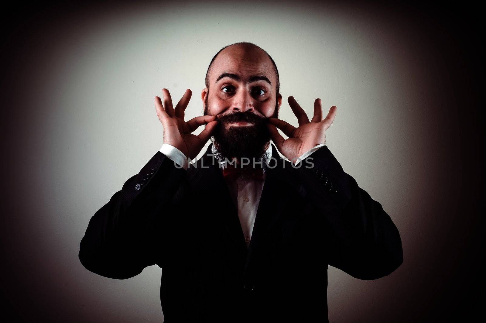  funny elegant bearded man touching mustache on vignetting background