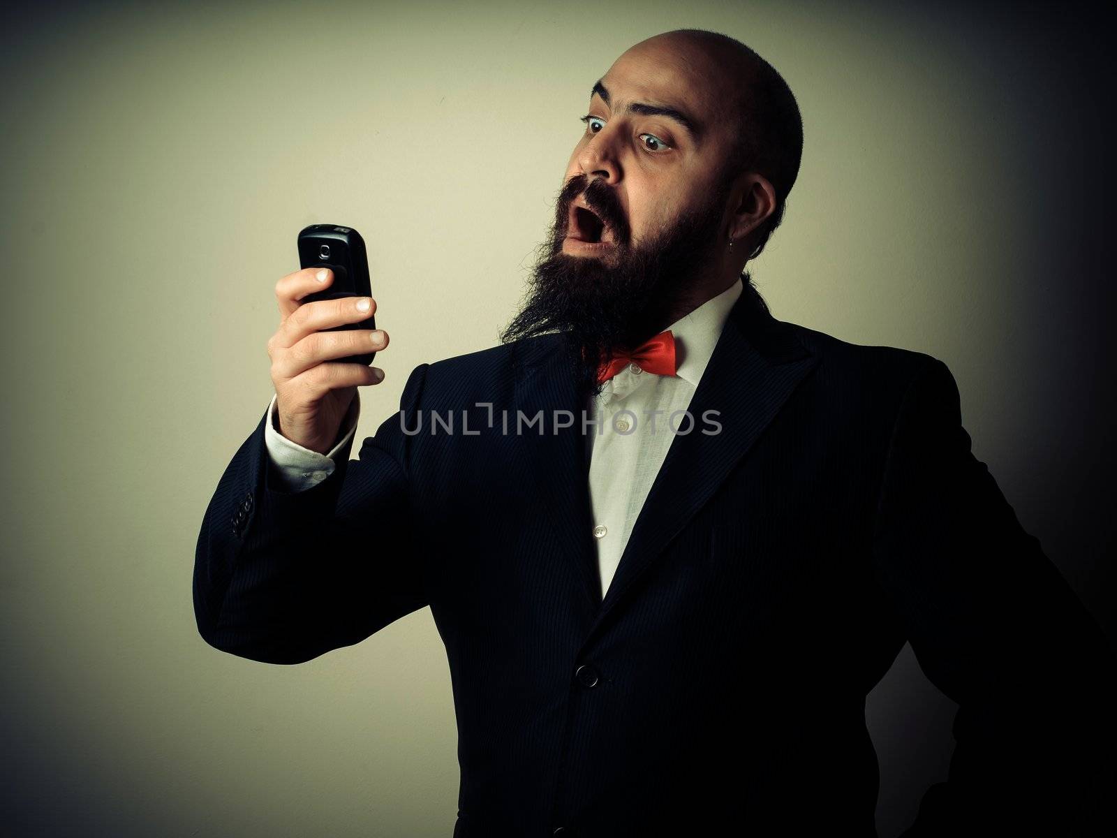  funny elegant bearded man on the phone on vignetting background