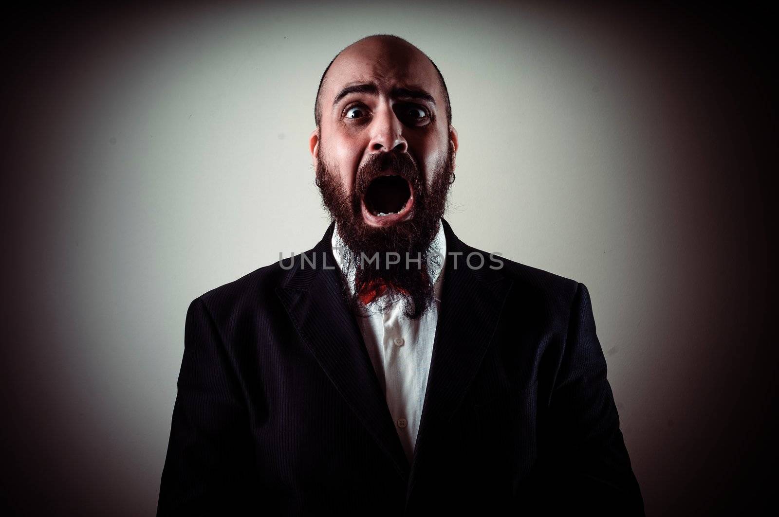 funny afraid elegant bearded man on vignetting background