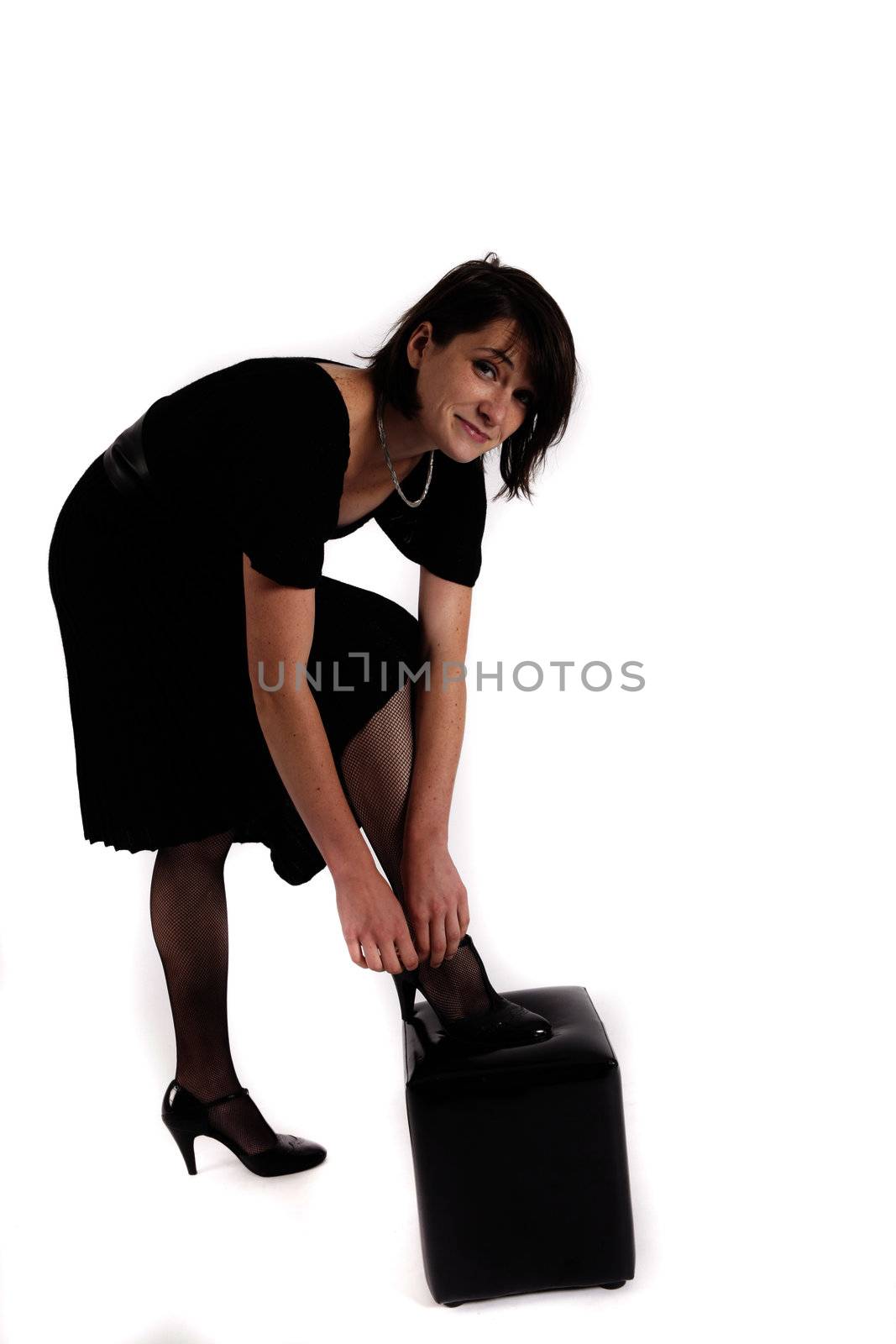 young brunette woman in black dress wearing her shoes by macintox