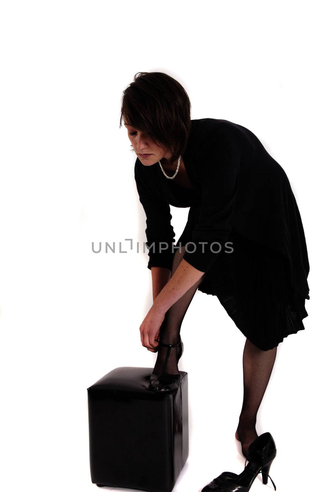 young brunette woman in black dress wearing her shoes by macintox