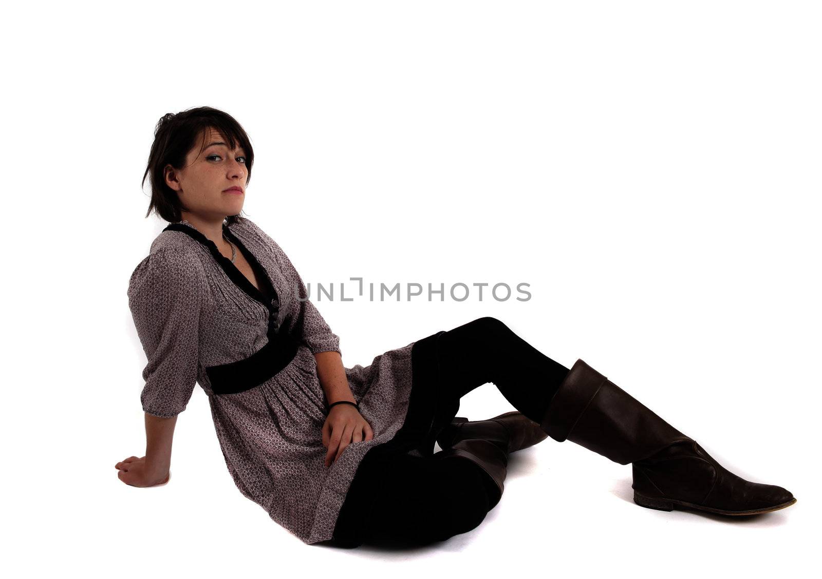 young brunette woman in dress sitting on the ground with boots