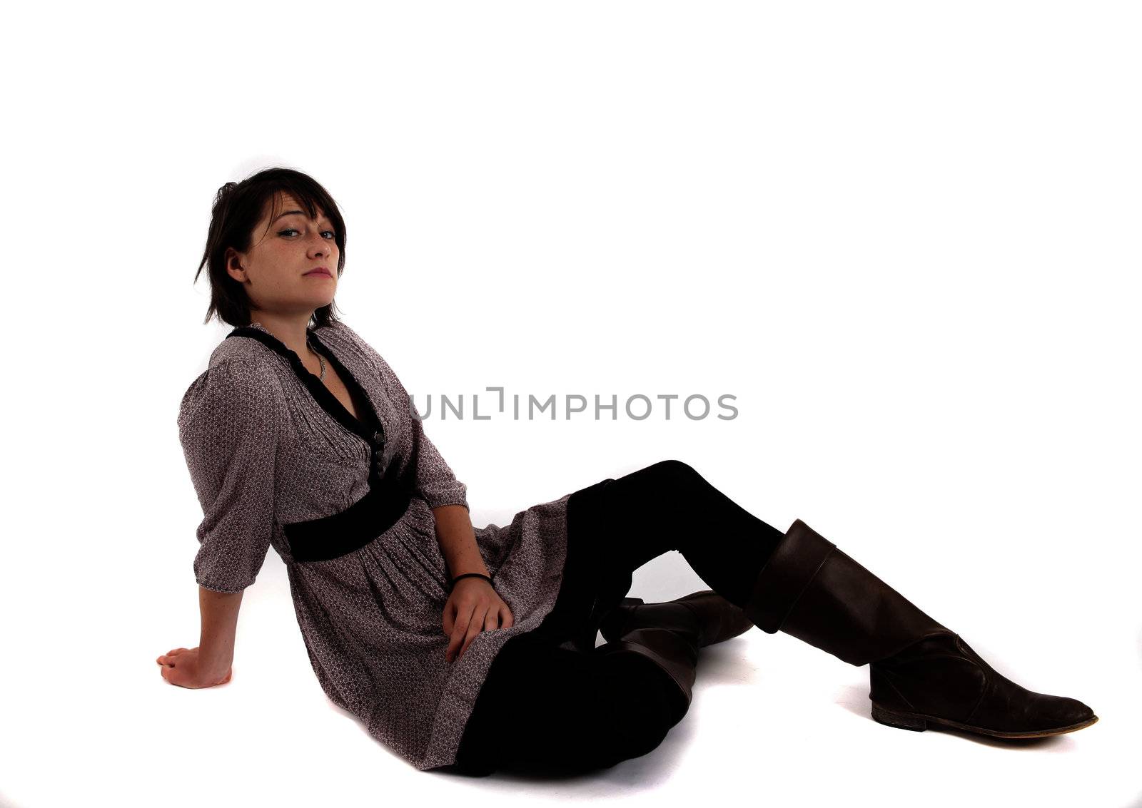 young brunette woman in dress sitting on the ground with boots