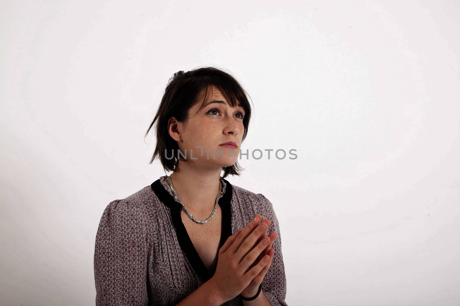 portrait of a young brunette woman requesting in catholic posture united hand