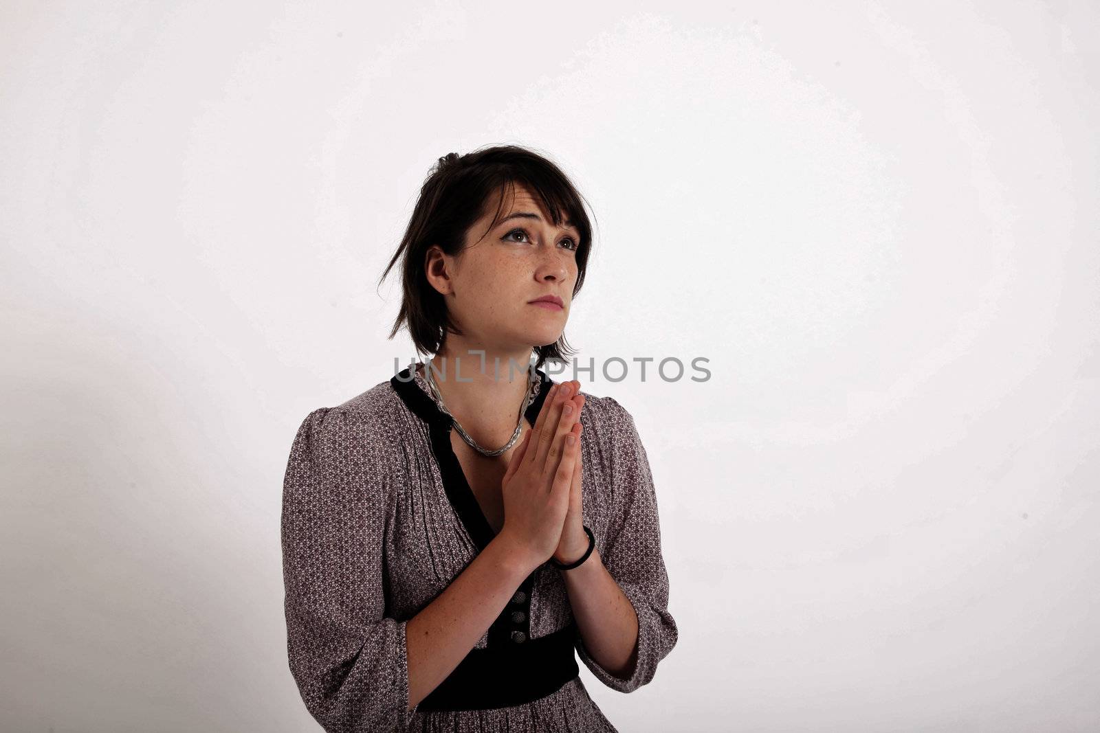 portrait of a young brunette woman requesting in catholic posture united hand