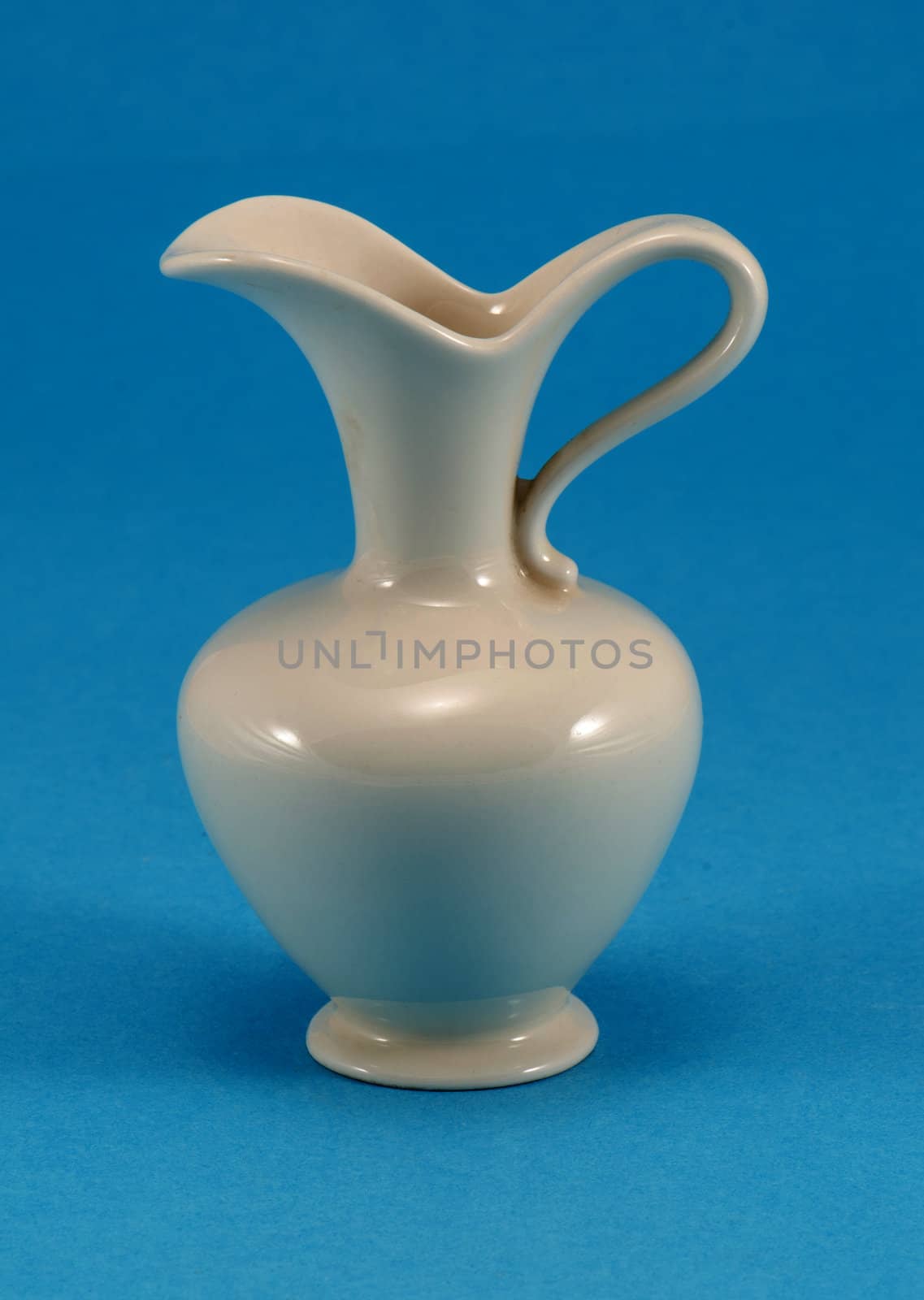 cute shape white ceramic pitcher jug jar on blue background.