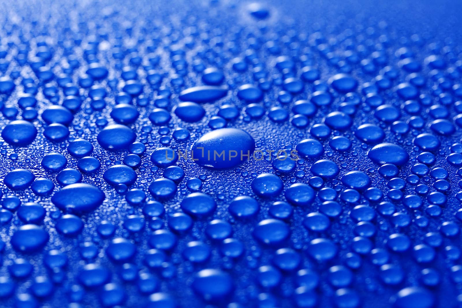 Water droplets on a blue metal background