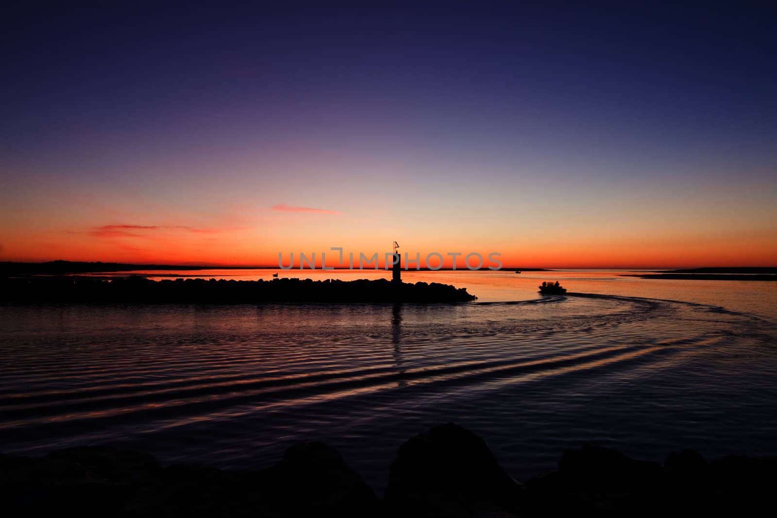 Beautiful view of the departure of a fishing boat in the early morning in Fuzeta, Portugal.