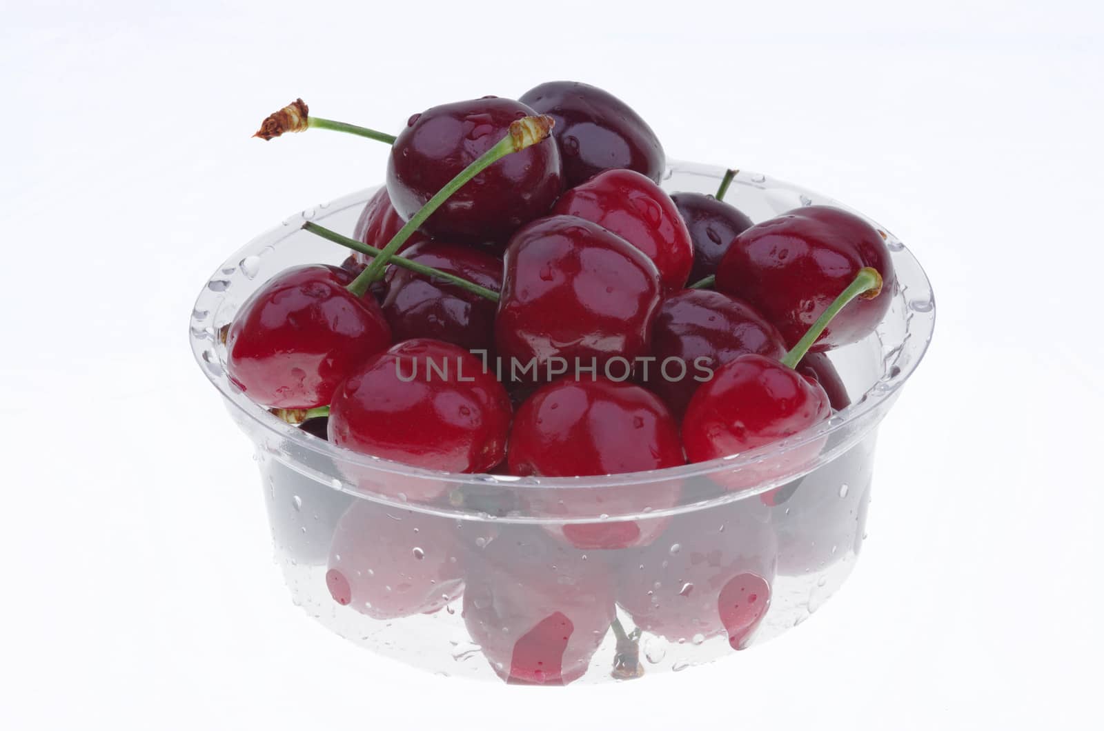 Transparent plastic box with cherry isolated on white