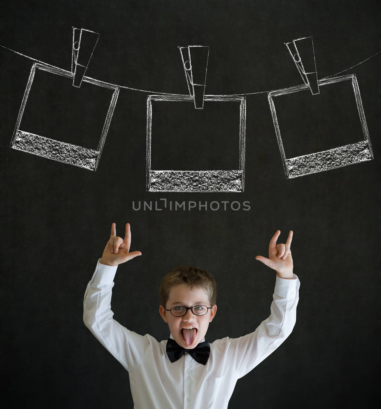 Knowledge rocks boy dressed up as business man with hanging instant photograph on blackboard background