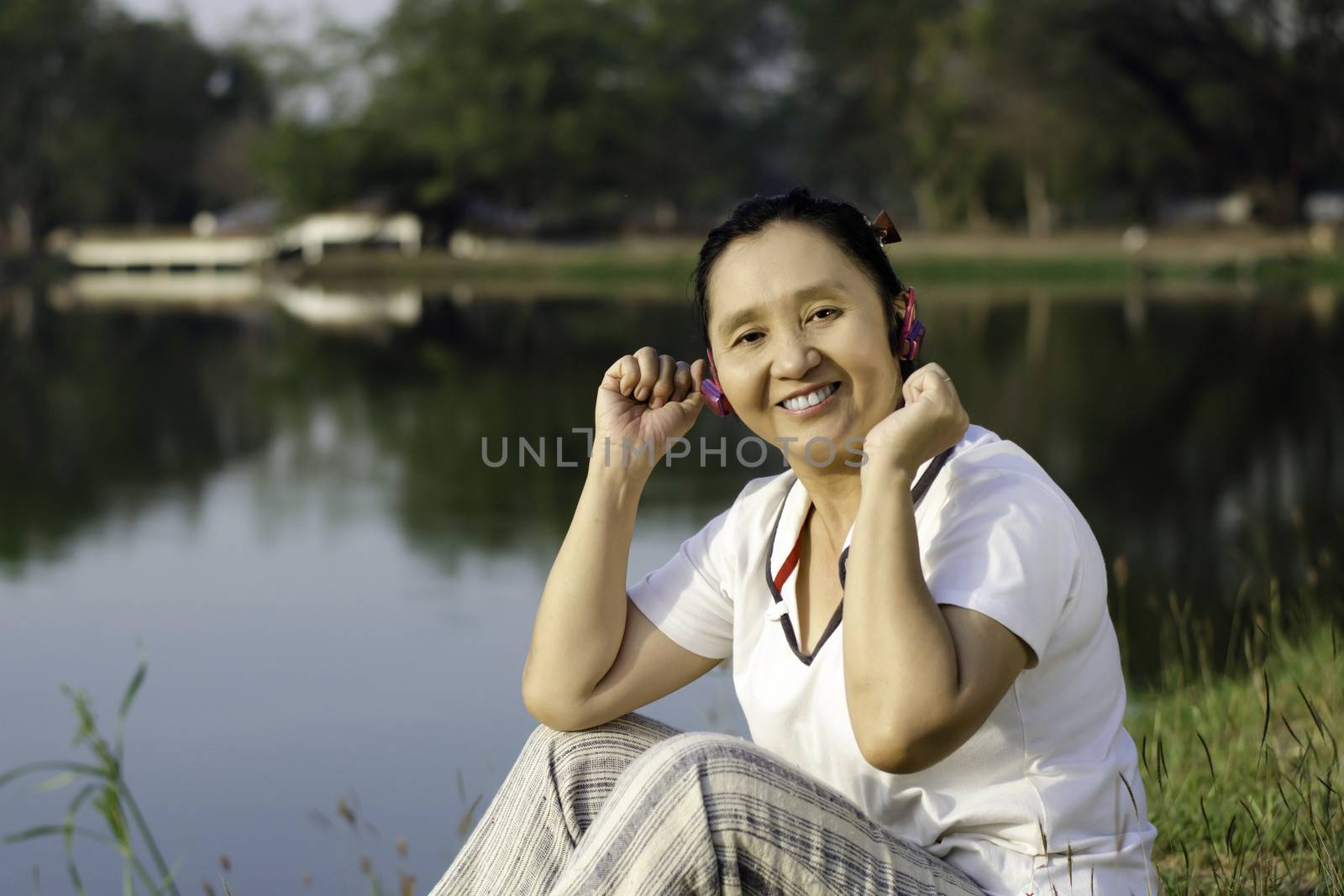 Beautiful asian woman listening music in headphones