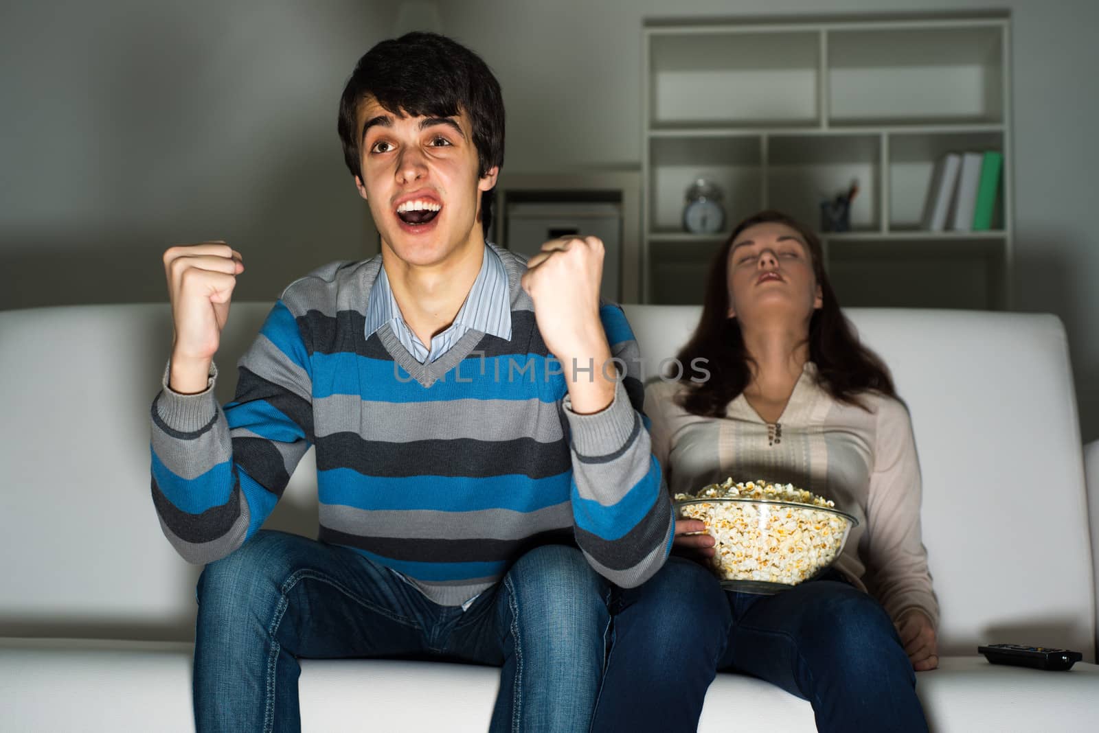 guy with a passion watching TV, sleeping next to his girlfriend on the couch