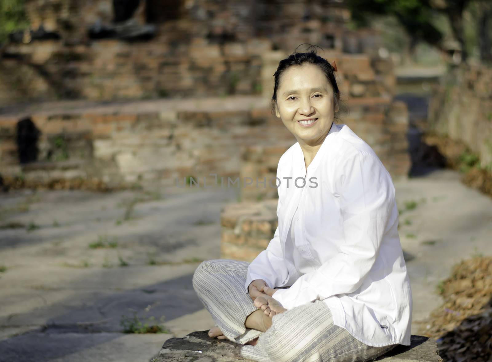Smiling woman meditating  by siraanamwong