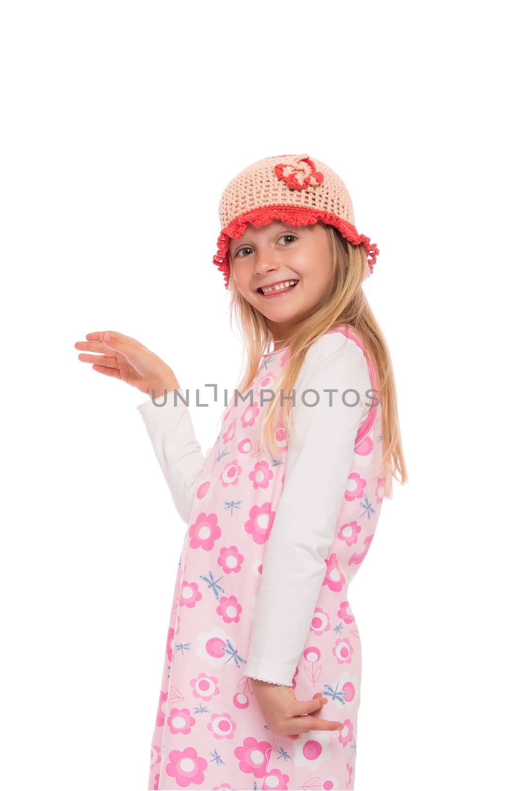 Smiling little girl with long hair wearing summer dress and knit cap. Isolated on white background.