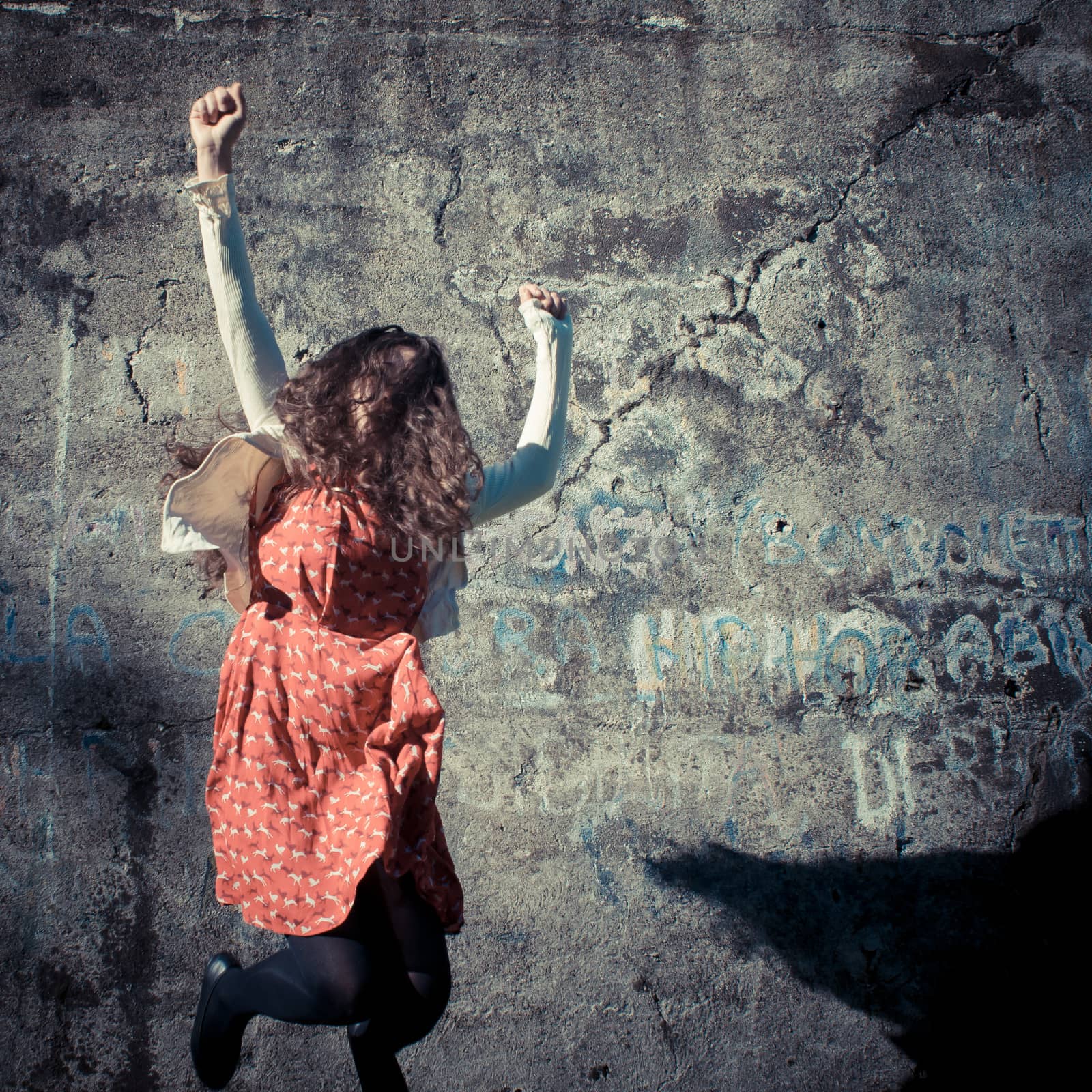 happy eastern vintage hipster woman jumping in the park