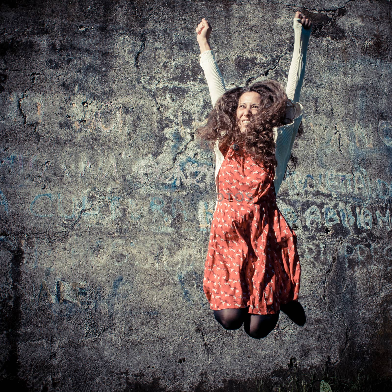 happy eastern vintage hipster woman jumping in the park