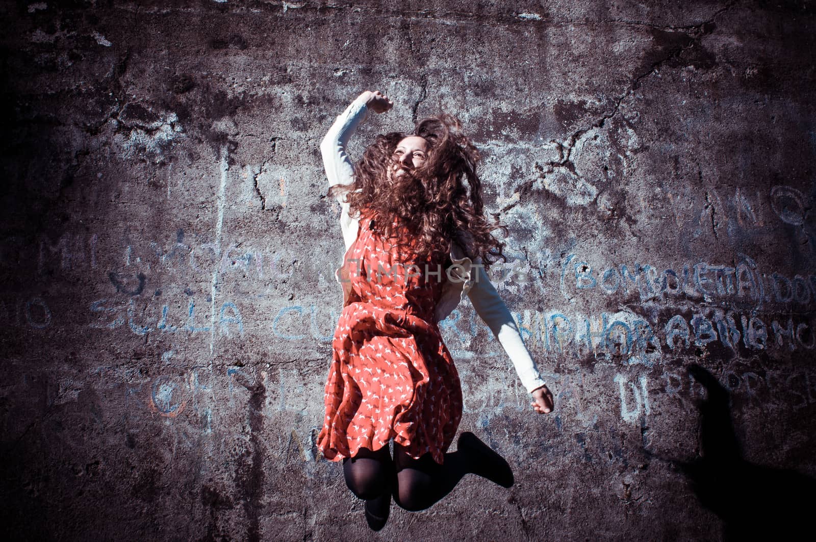 happy eastern vintage hipster woman jumping in the park