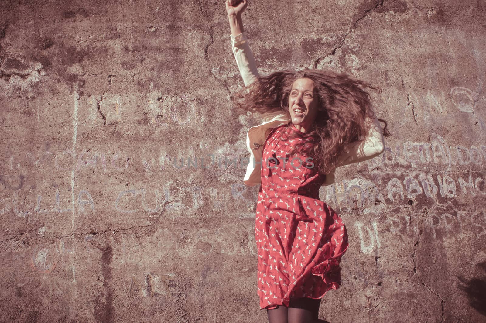 happy eastern vintage hipster woman jumping in the park