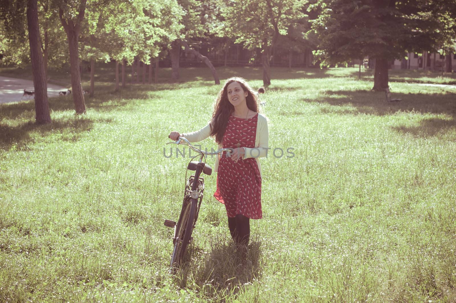 vintage eastern hipster woman with bike in the park