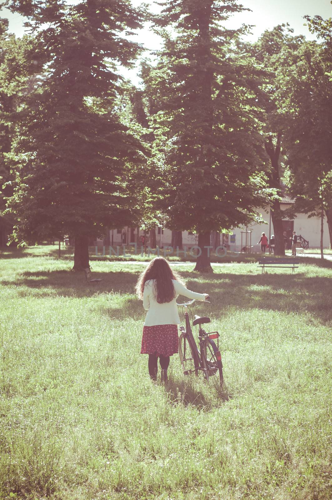 vintage eastern hipster woman with bike in the park