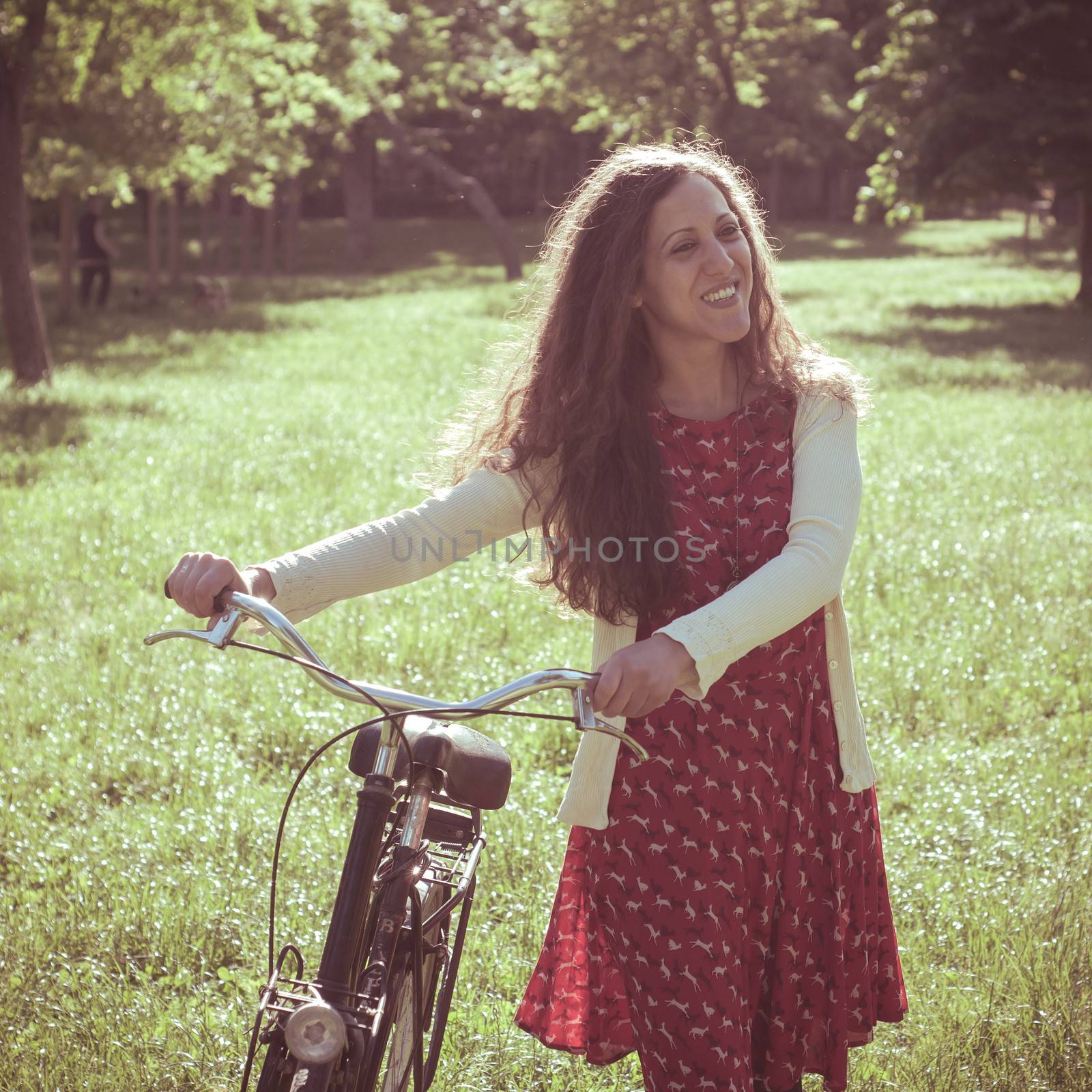 vintage eastern hipster woman with bike in the park