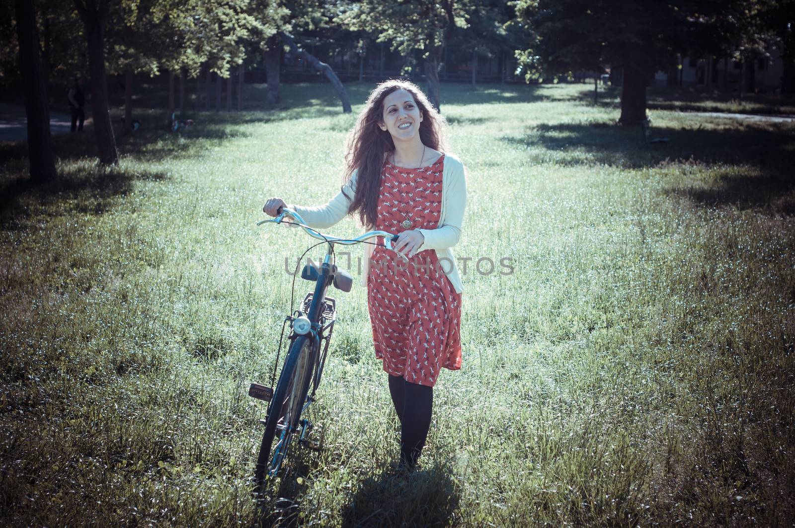 vintage eastern hipster woman with bike in the park