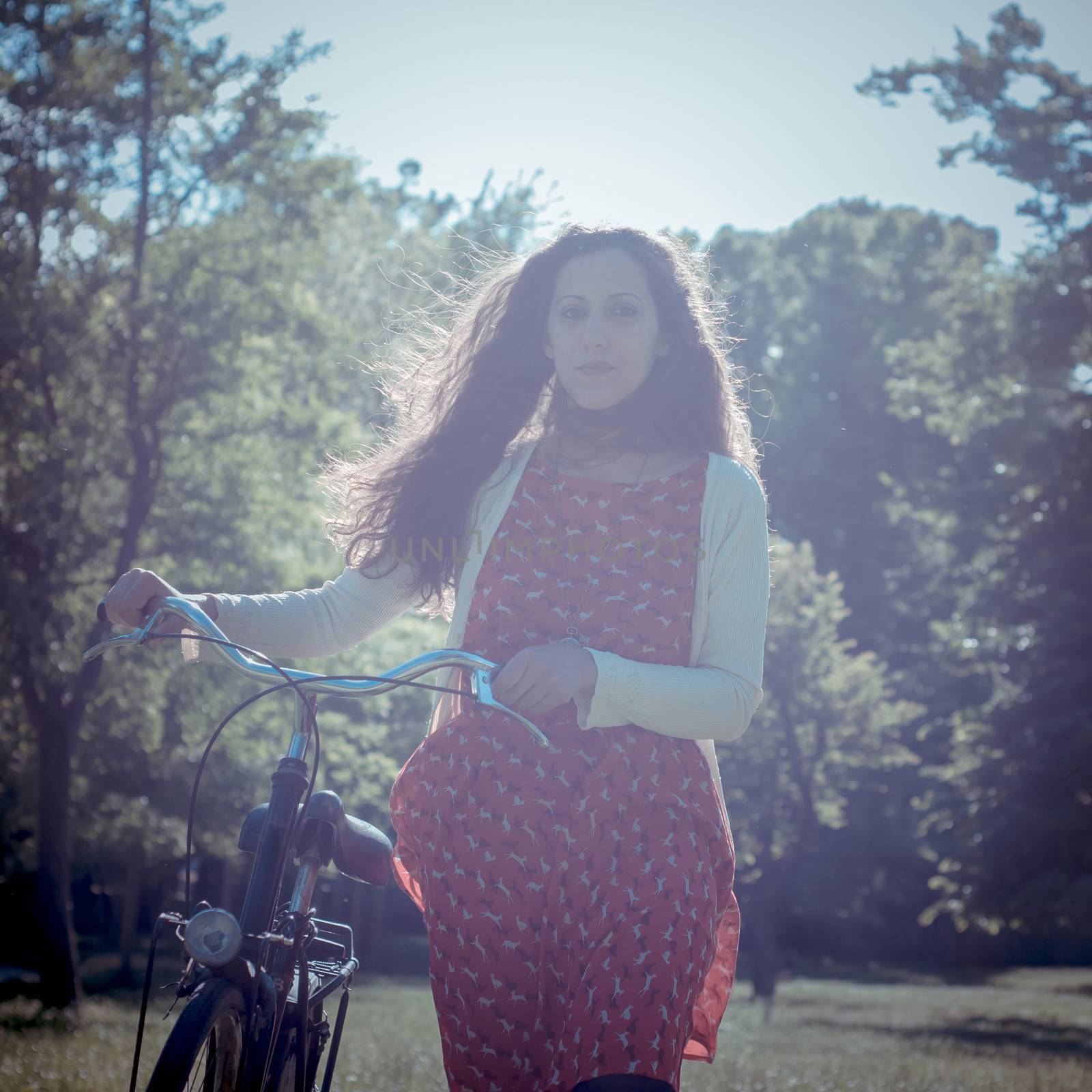 vintage eastern hipster woman with bike in the park