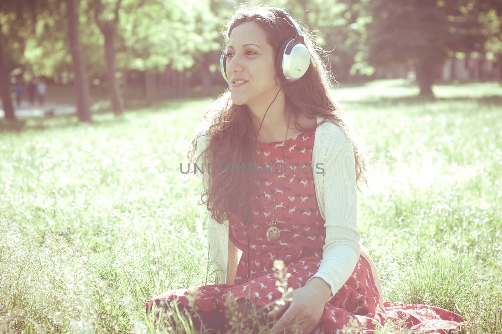 vintage hipster eastern woman with headphones in the park