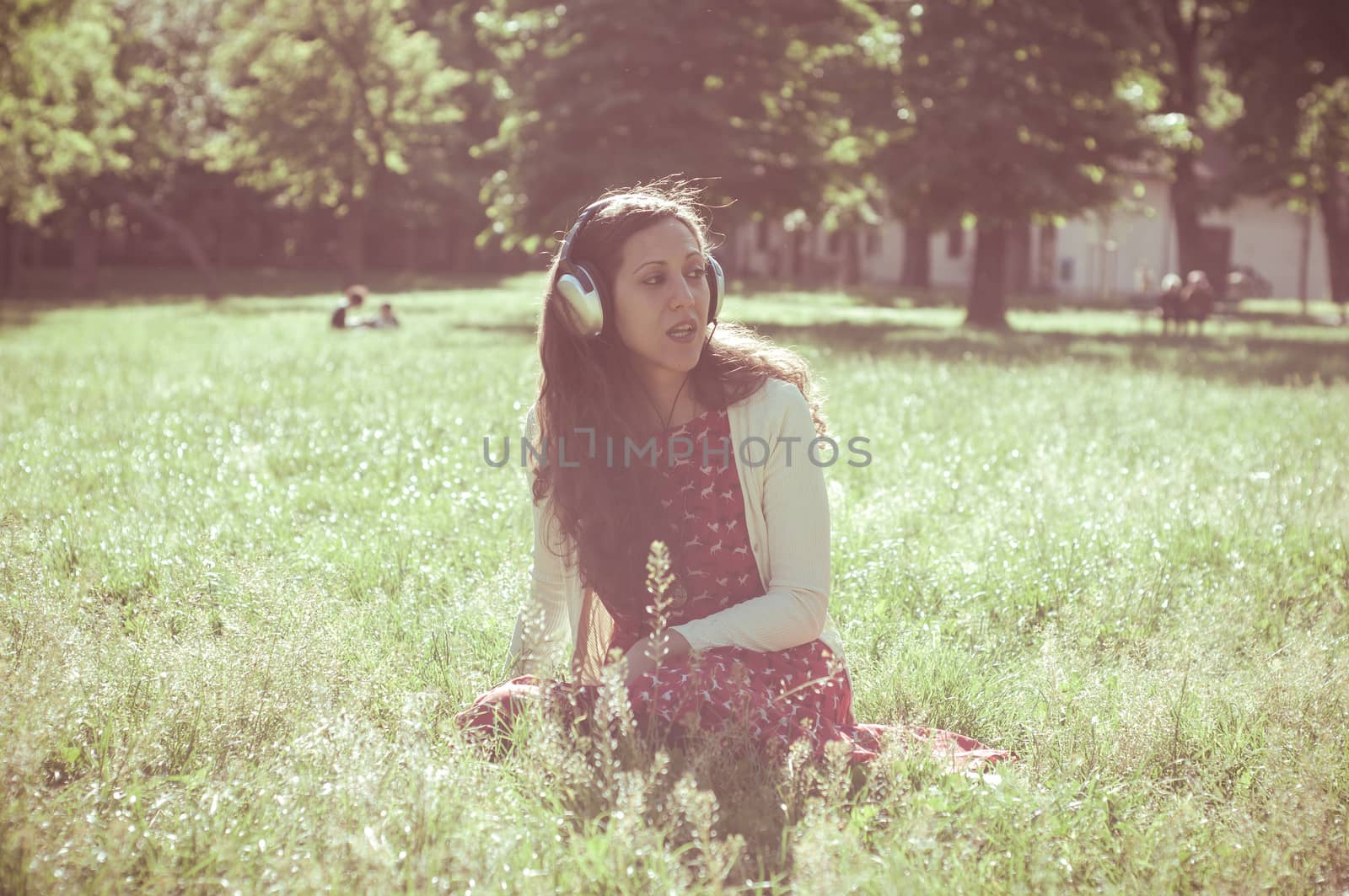 vintage hipster eastern woman with headphones in the park