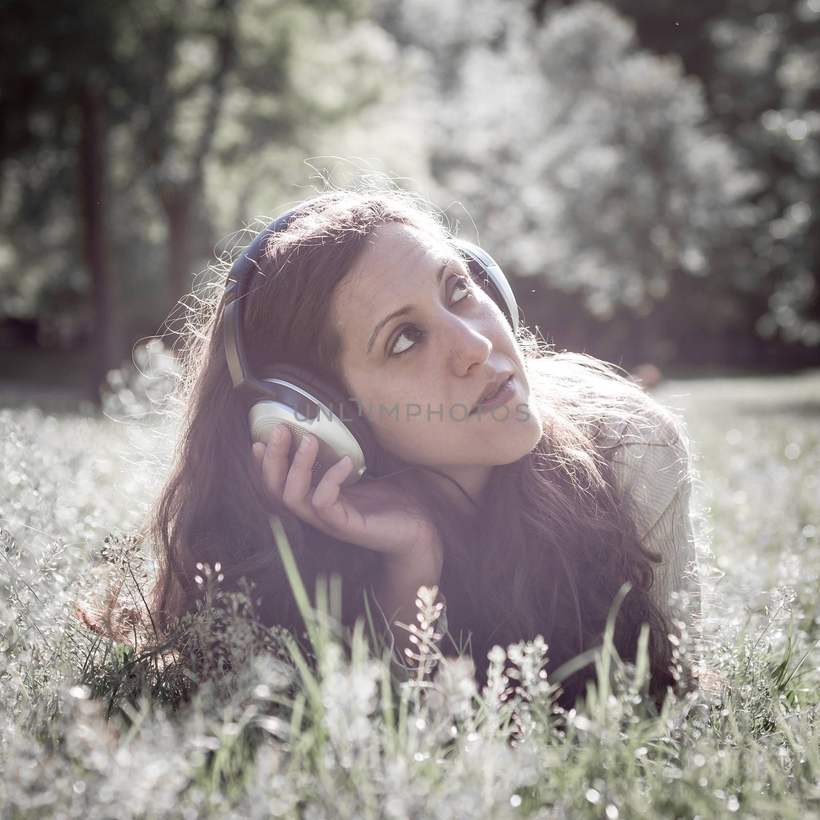 vintage hipster eastern woman with headphones in the park