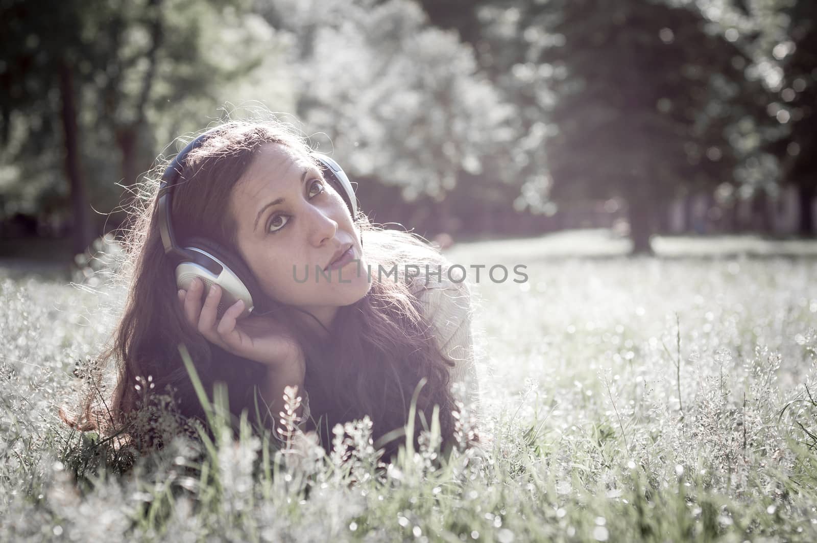 vintage hipster eastern woman with headphones in the park