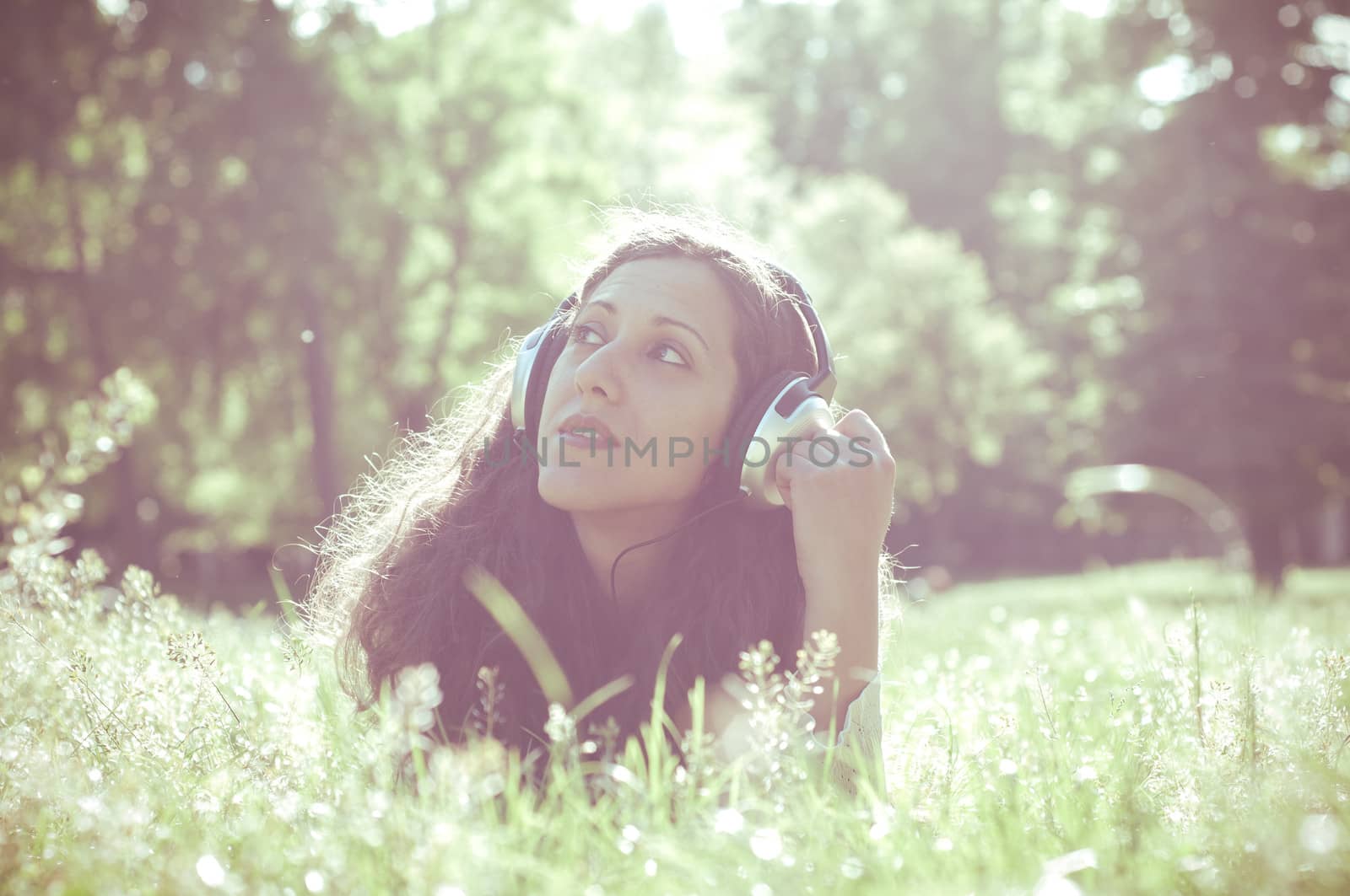 vintage hipster eastern woman with headphones in the park