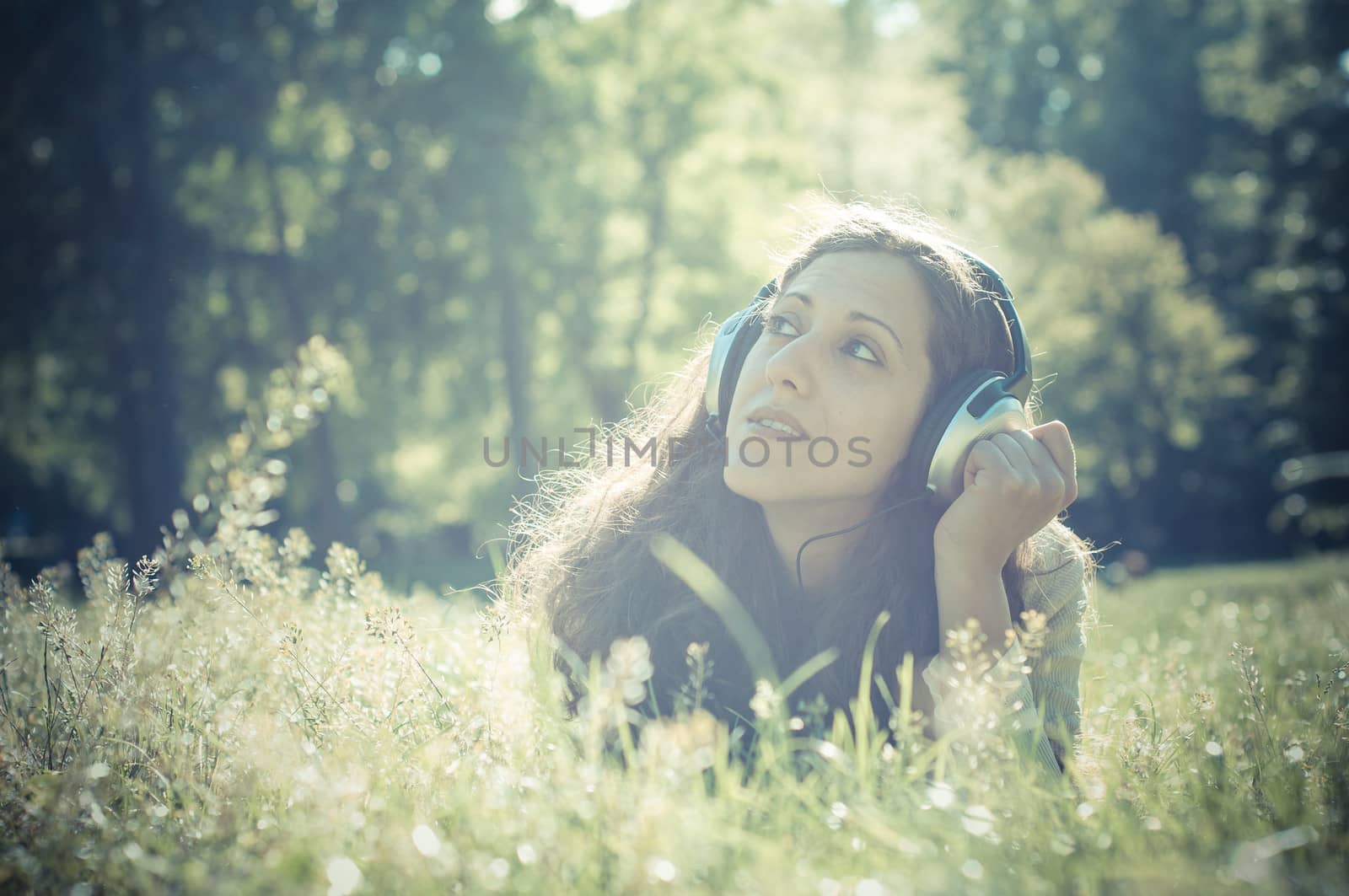vintage hipster eastern woman with headphones in the park