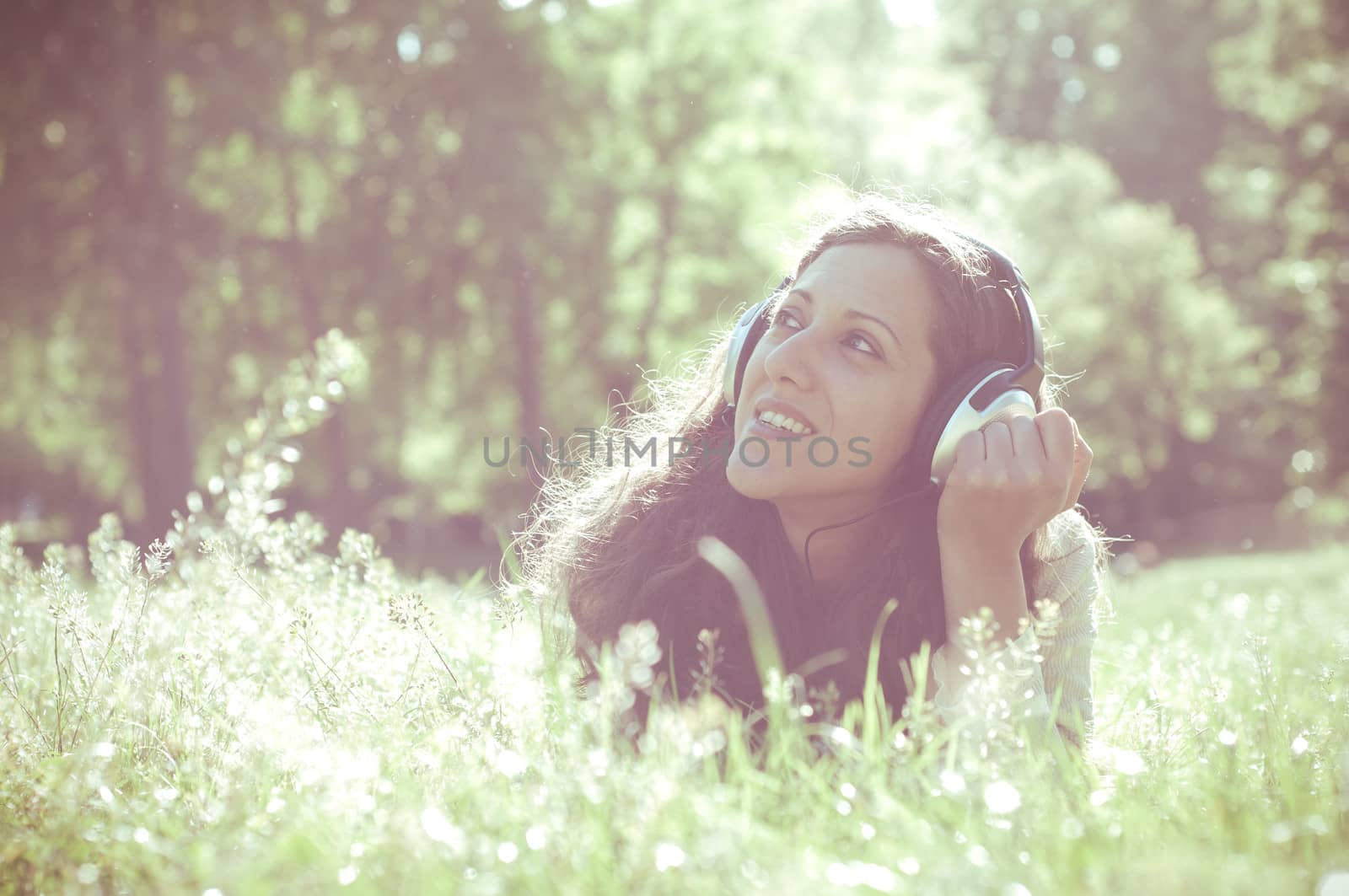 vintage hipster eastern woman with headphones in the park