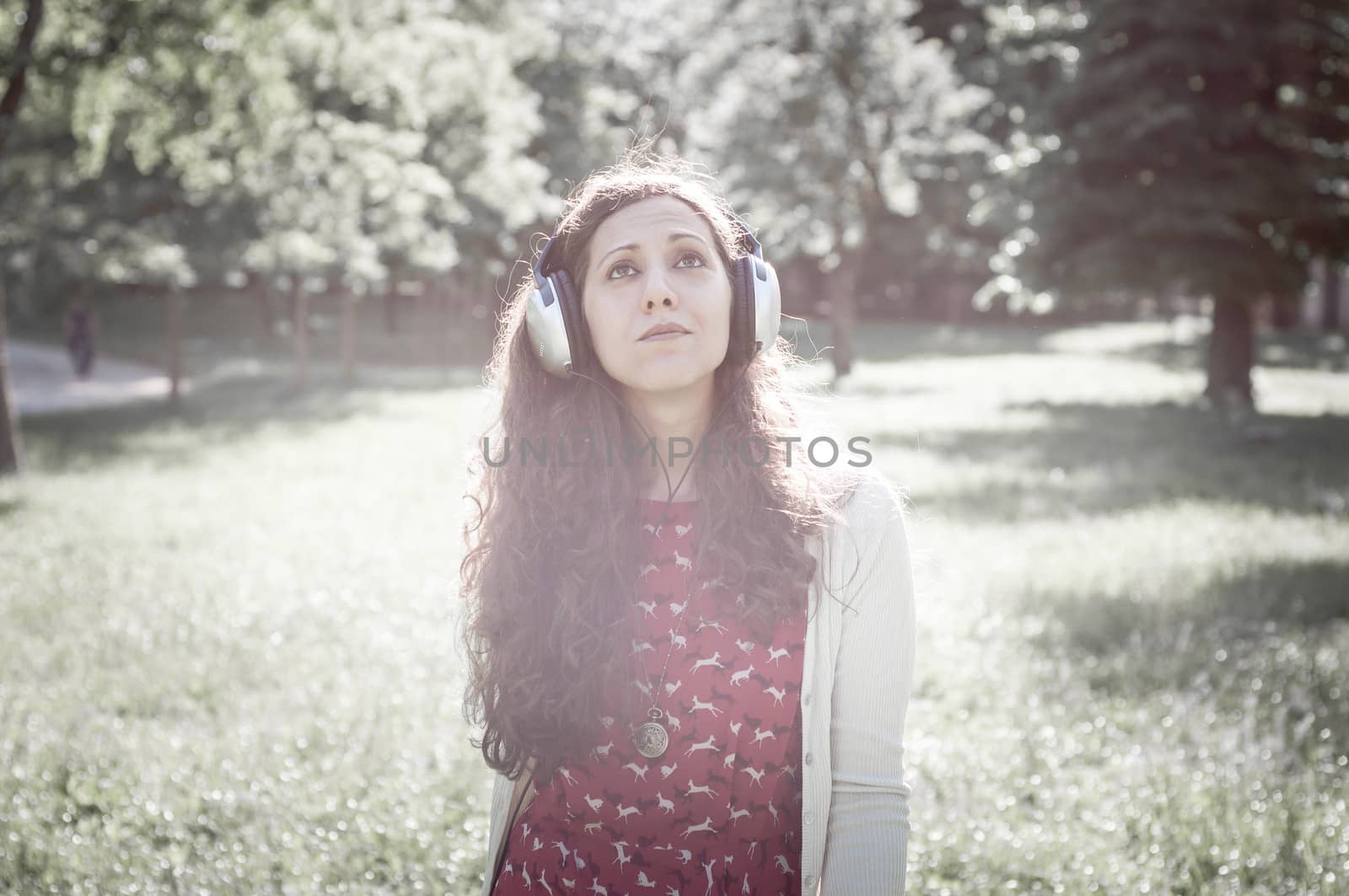 vintage hipster eastern woman with headphones in the park