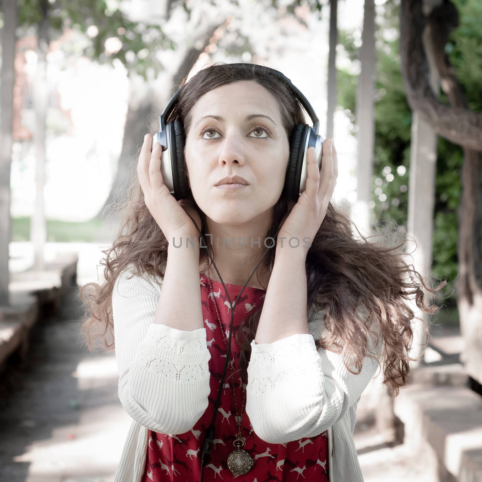 vintage hipster eastern woman with headphones in the park