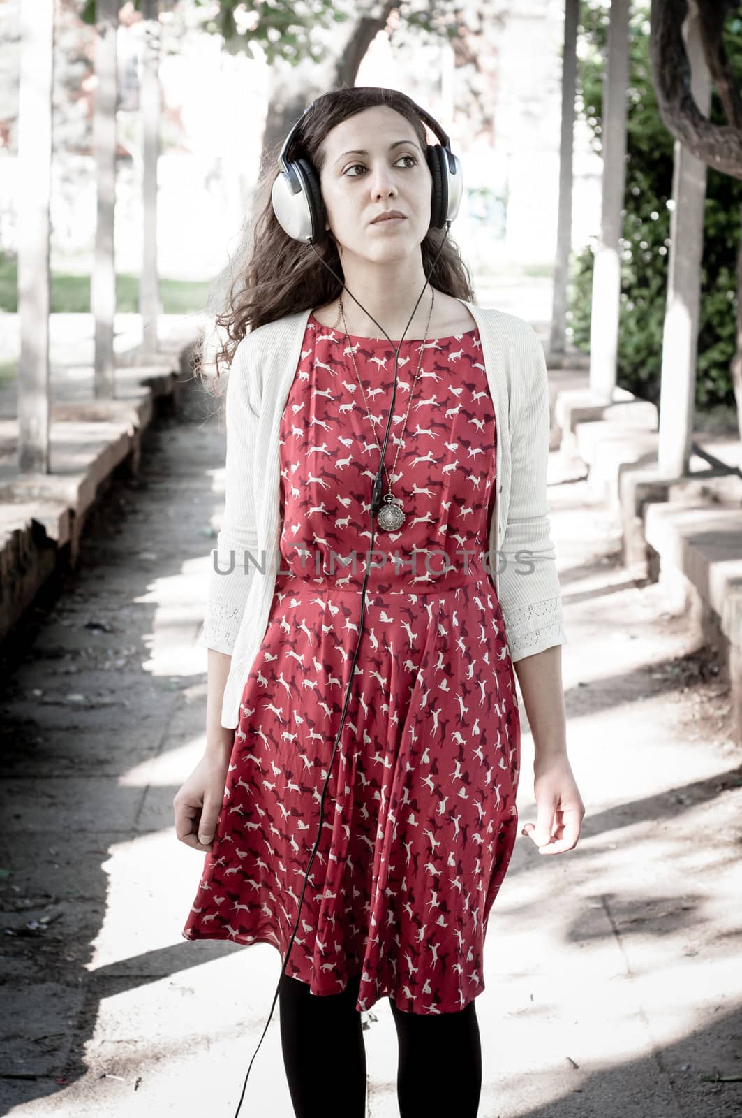 vintage hipster eastern woman with headphones in the park