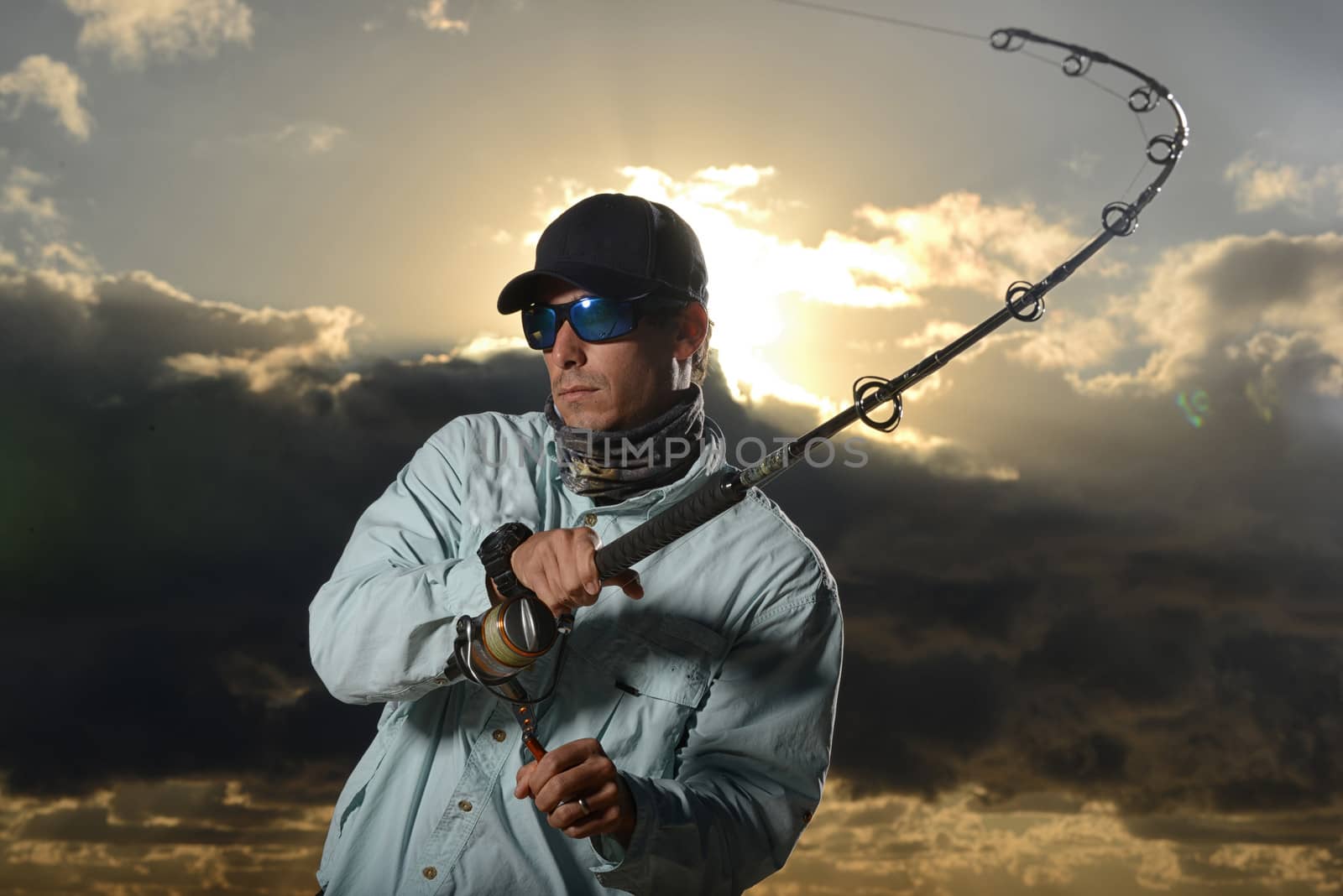 man fishing with beautiful sunset in background