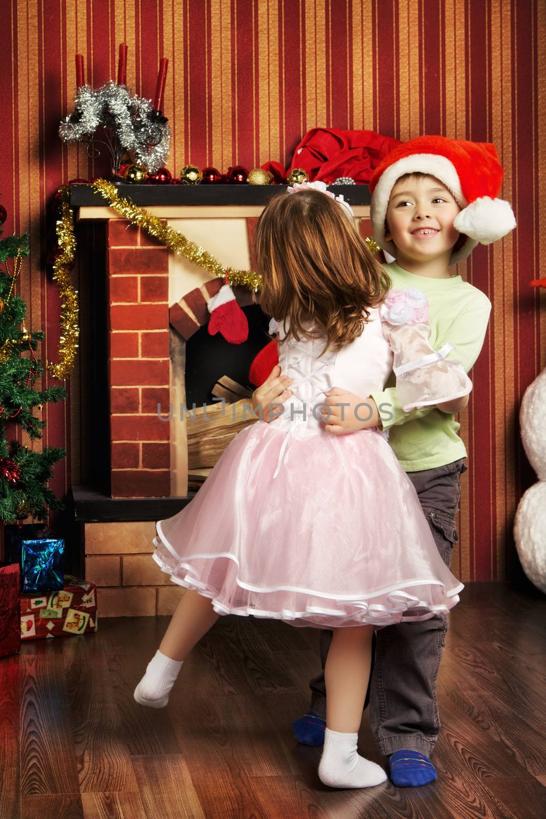 two beautiful child dancing near christmas tree