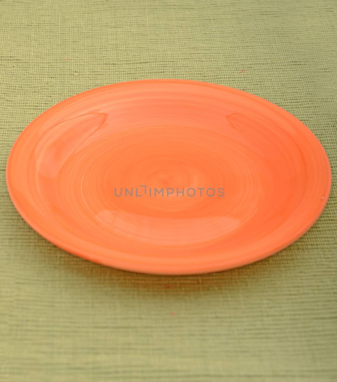 empty orange plate on a green textured background